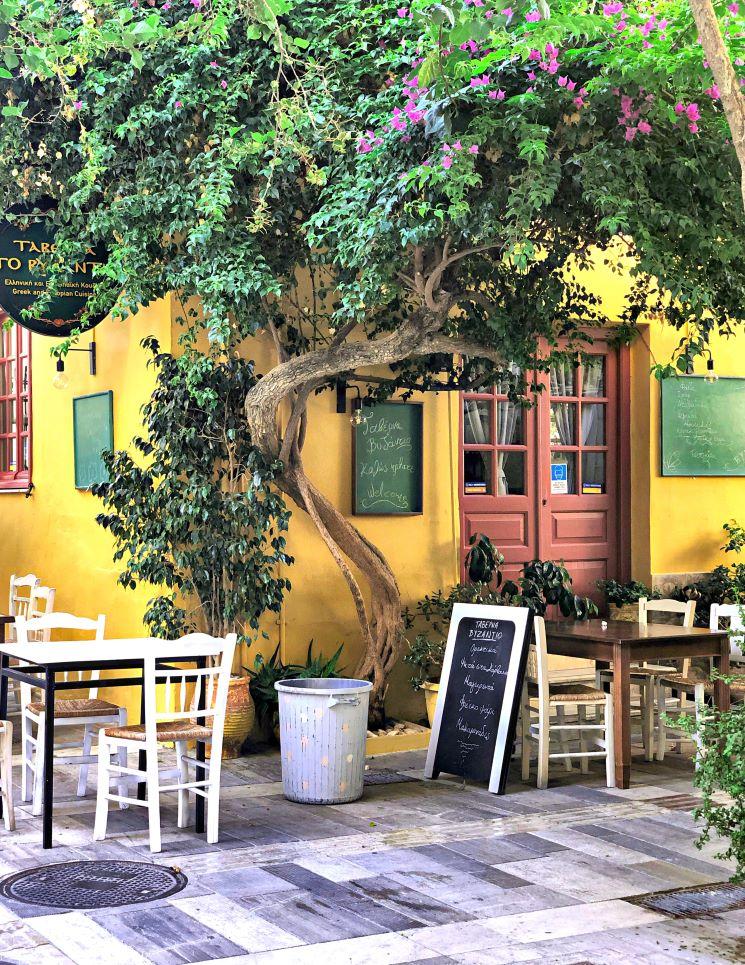Des tables sous un arbre dans une taverne en Grèce