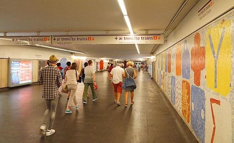 des passagers marchent dans un tunnel de métro à rome