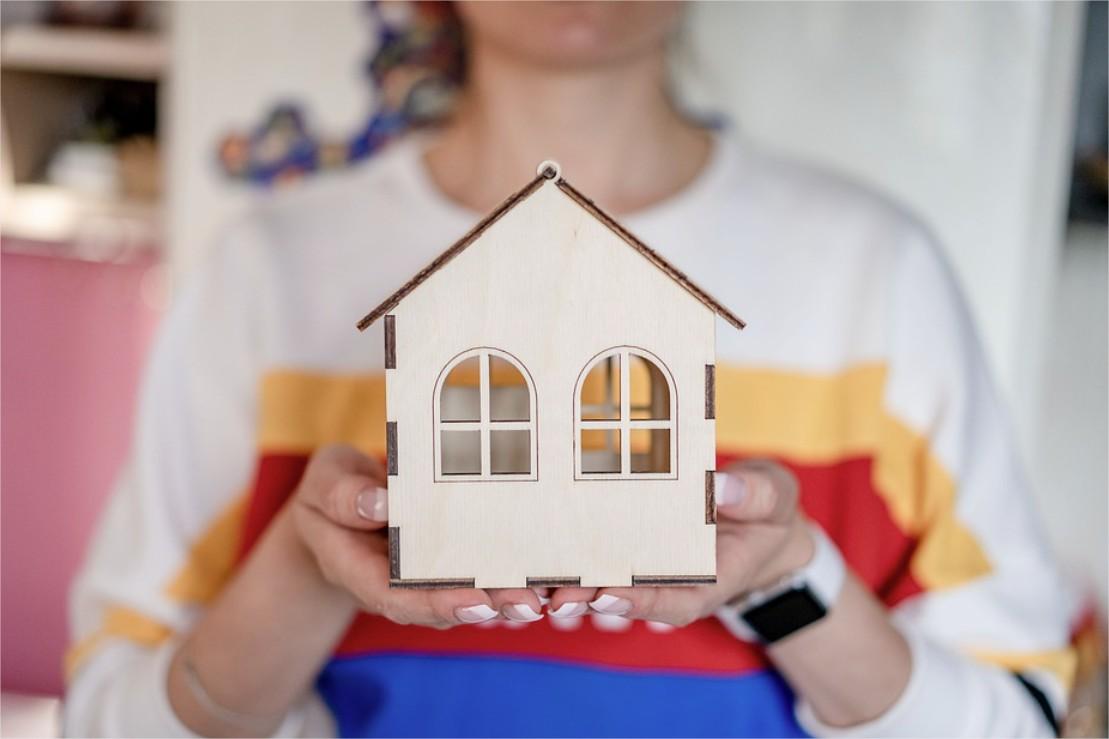 Petite fille tenant une maison dans les mains
