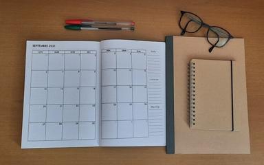 agenda ouvert avec des lunettes et un stylo