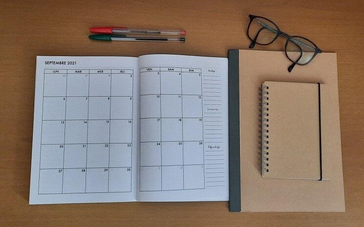 agenda ouvert avec des lunettes et un stylo