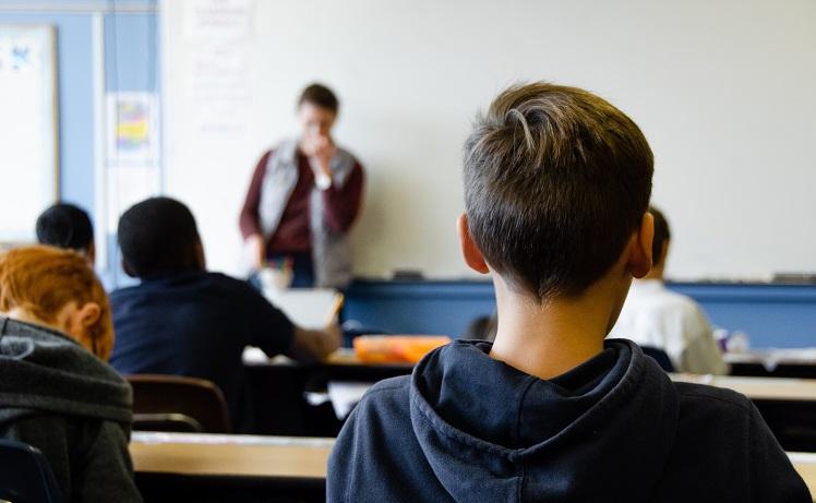 des élèves dans une salle de classe face au tableau