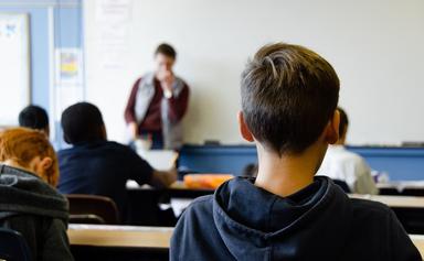 des élèves dans une salle de classe face au tableau