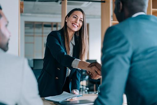 Homme et femme se serrant la main dans un bureau