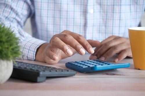 Main d'un homme qui tape à la calculatrice