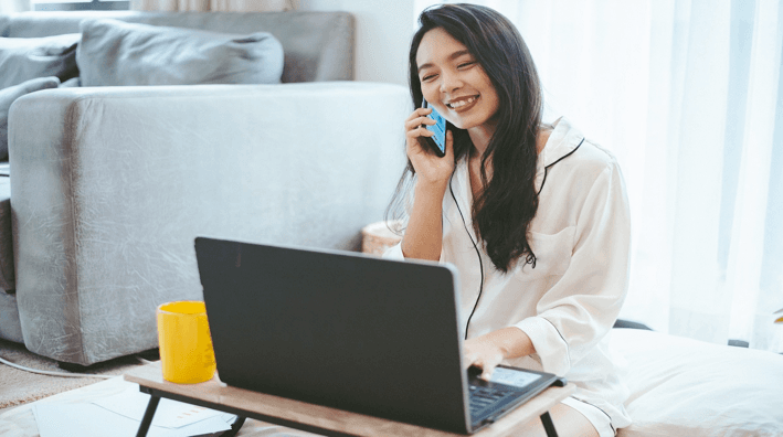 Femme au téléphone devant son ordinateur