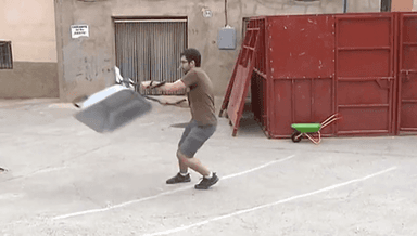 un homme lance une brouette dans la rue en Espagne