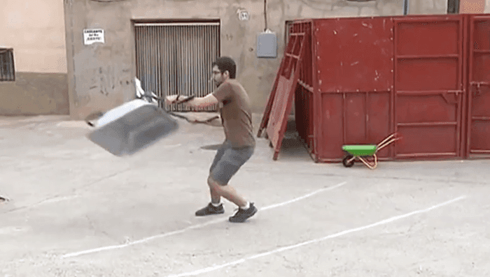 un homme lance une brouette dans la rue en Espagne