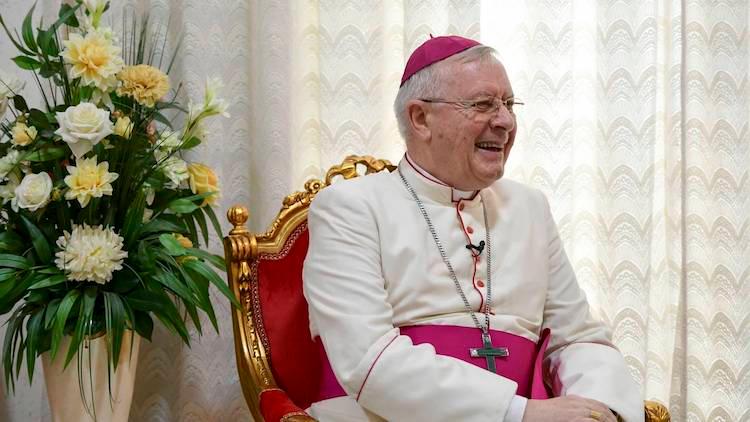 Paul Hinder, évêque aux Emirtats Arabes souriant sur une chaise