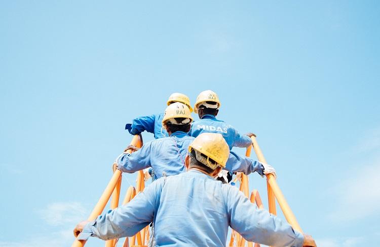 des ingénieurs en construction montent l'échelle d'une grue