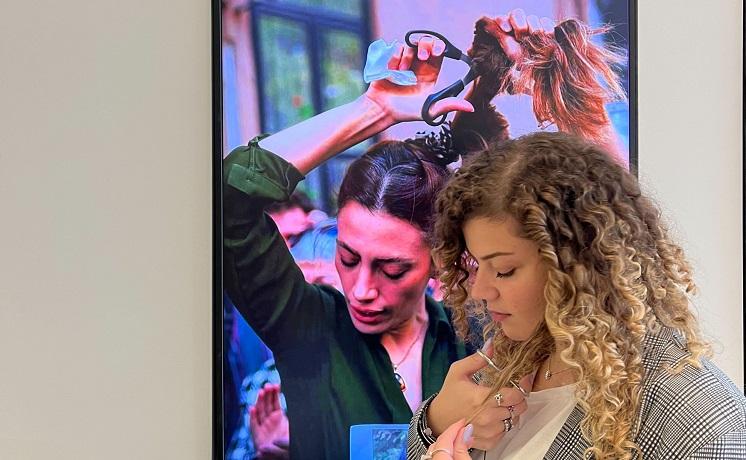 une jeune femme se coupe une mèche de cheveux