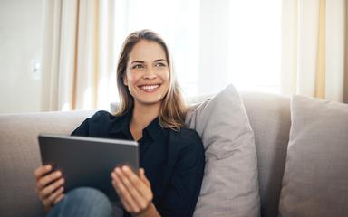 Femme sur un canapé gérant son épargne