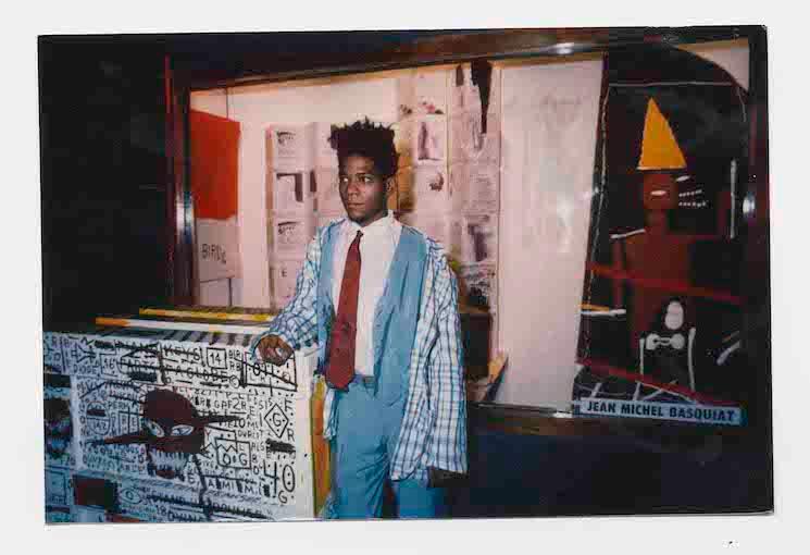 Jean-Michel Basquiat devant ses oeuvres
