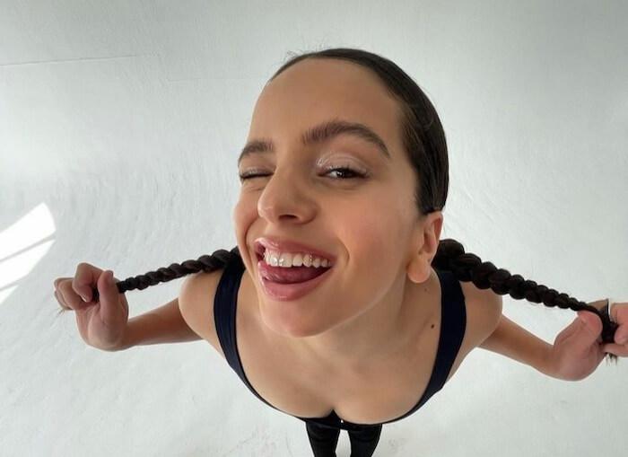 une femme avec des queues de cheval en train de montrer ses bijoux dentaires