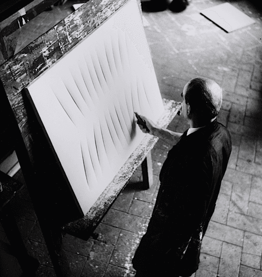 Shunk-Kender, Lucio Fontana trabajando en su estudio, París, ca. 1958. Bibliothèque Kandinsky, Centre Pompidou. Fonds Fontana. © Lucio Fontana a través de SIAE 2022.