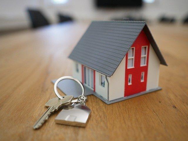 Un guide logement avec une maquette de maison et une clé