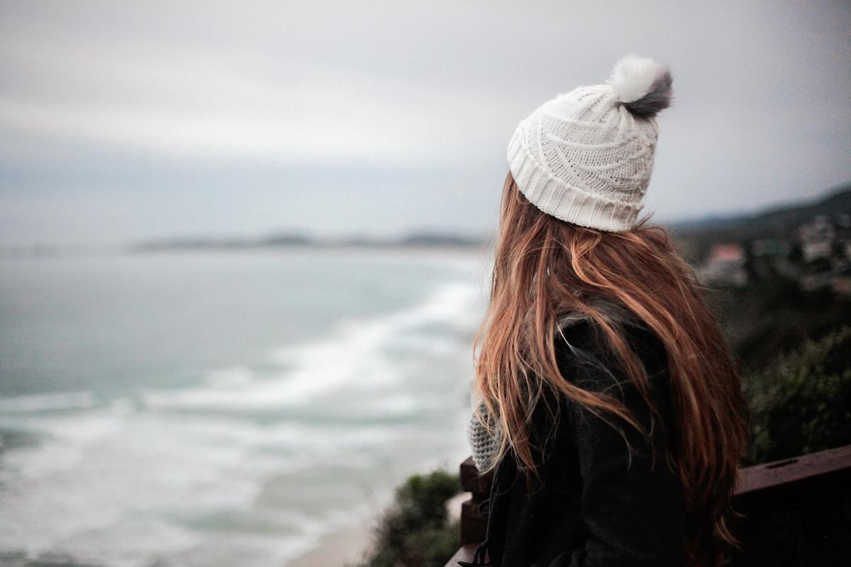 Une jeune fille au bord de la Méditerranée par temps froid