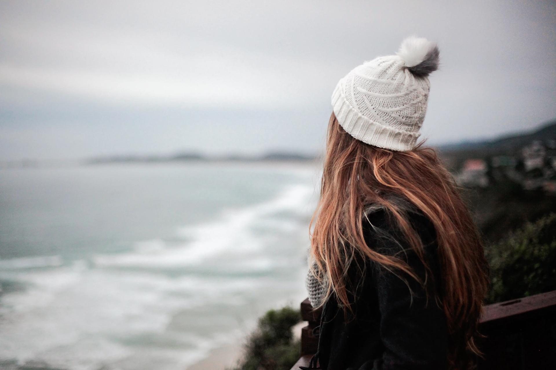 Une jeune fille au bord de la Méditerranée par temps froid