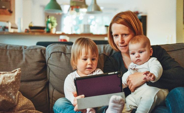 Une mère avec ses enfants devant une tablette