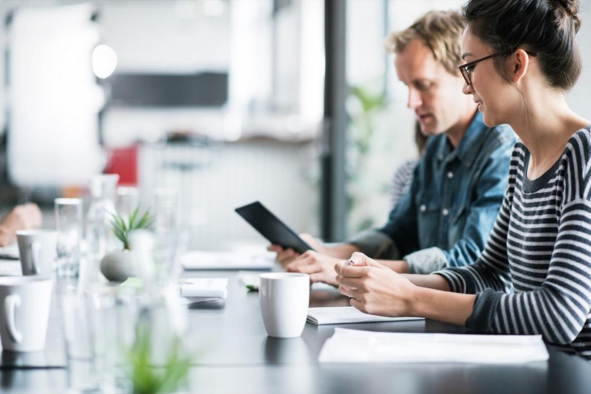 deux personnes assises a un bureau discutent