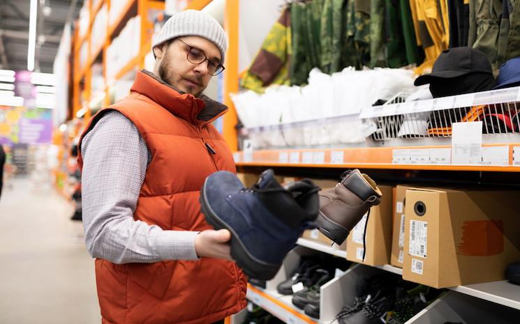 a-man-in-a-hardware-store-chooses-safety-shoes-for-2022-11-18-20-52-11-utc