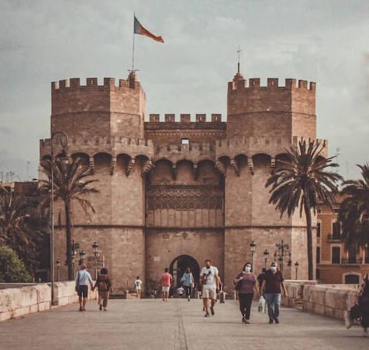 des piétons en train de marcher devant les portes de la ville de Valencia pendant les Fallas 2023