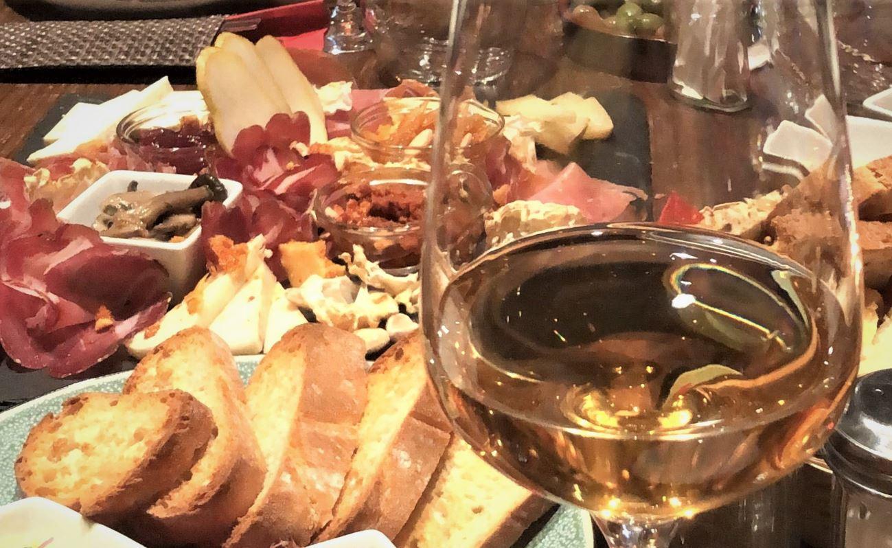 Une table avec des antipasti et un verre de vin au zerostress weinbar à Berlin