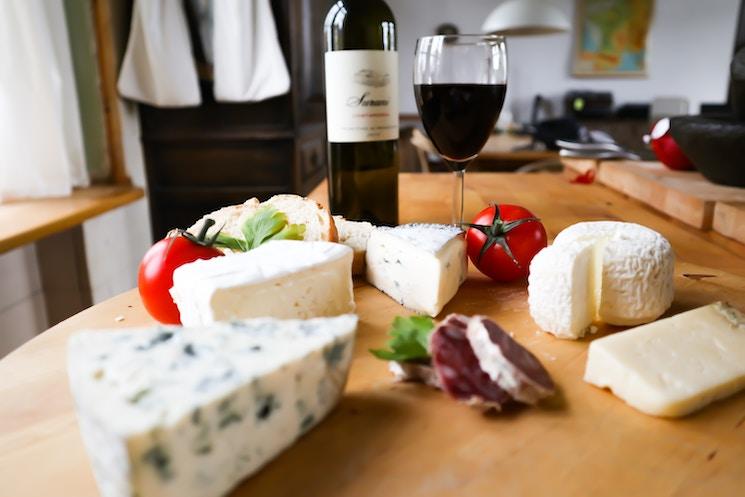 Du fromage avec du saucisson et une bouteille de vin sur la table