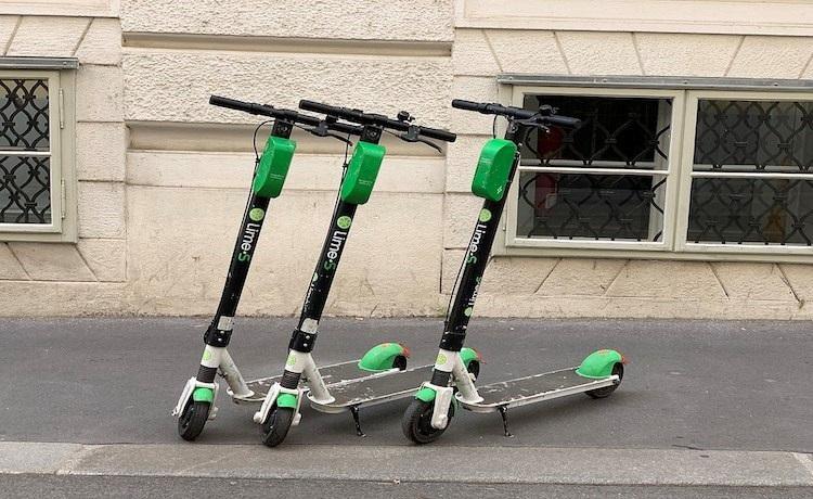 trois trotinettes électriques Lime sur le trottoir