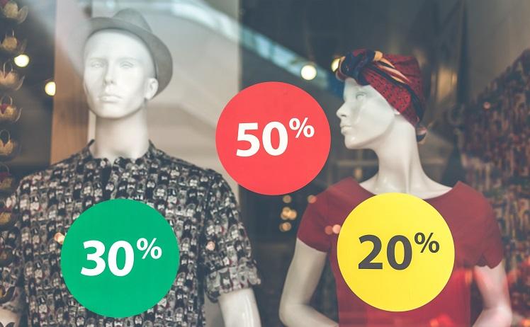 Des mannequins dans une vitrine de magasin avec des soldes