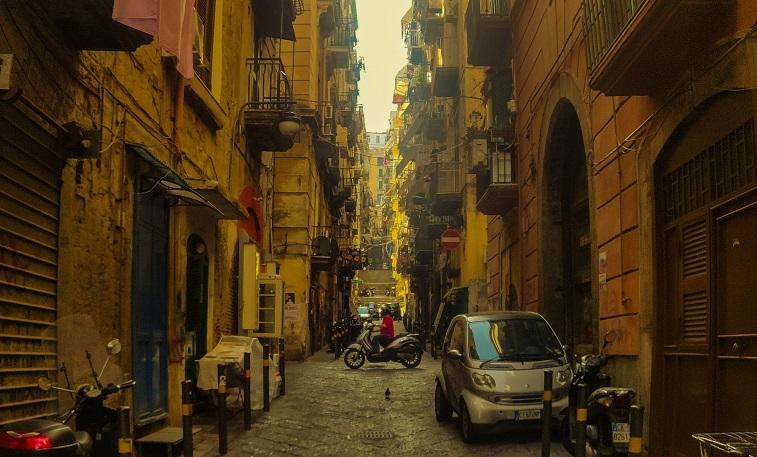 Voiture garée sur le côté de la rue au milieu d'immeubles - banana-banana-unsplash