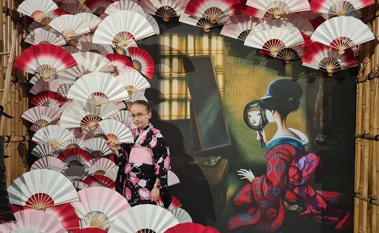 fillette habillée en kimono japonais au milieu d'éventails