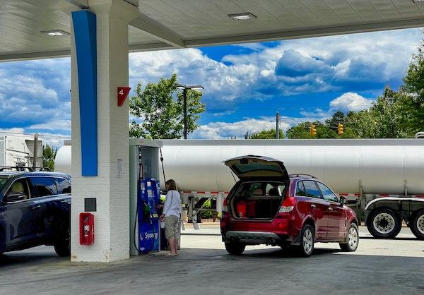 une femme prend de l'essence à la station service
