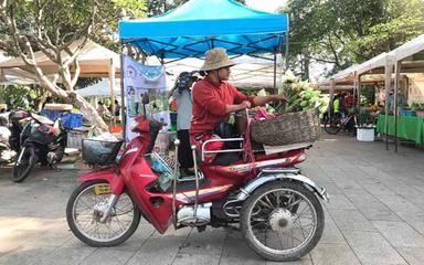 Choi Sokha commence à présenter les fleurs de lotus qu'elle vend au marché biologique de la province de Siem Reap.