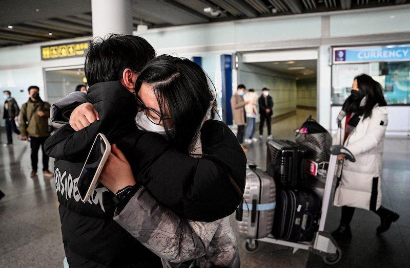 des personnes s'embrassent en chine apres ouverture frontiere covid