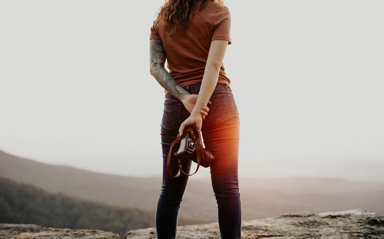 femme debout avec son appareil photo face au paysage brooke-cagle-unsplash