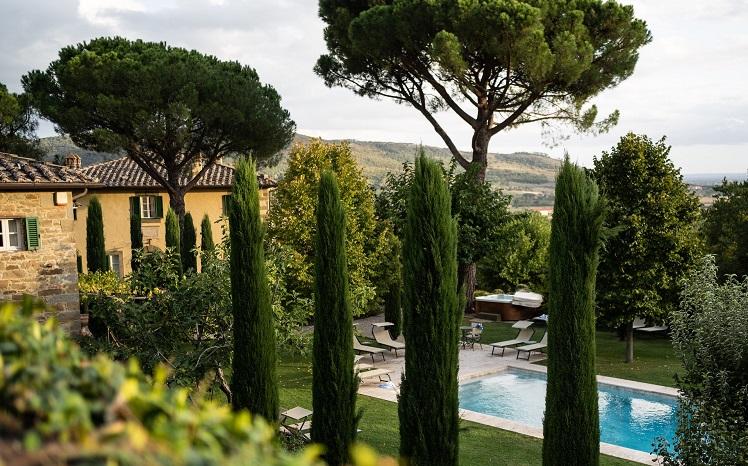 piscine entourée d'arbres et villa jaune en Italie