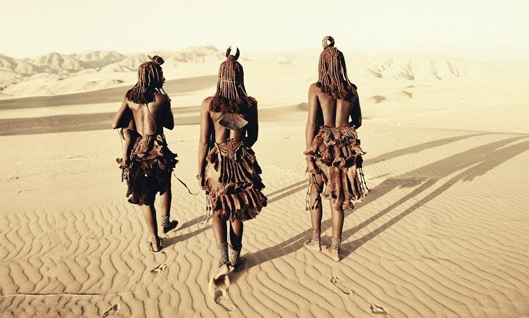 trois indigènes marchent dans le desert