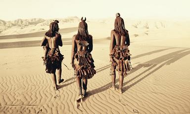 trois indigènes marchent dans le desert