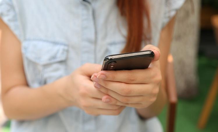 une jeune fille tient un téléphone portable dans ses mains