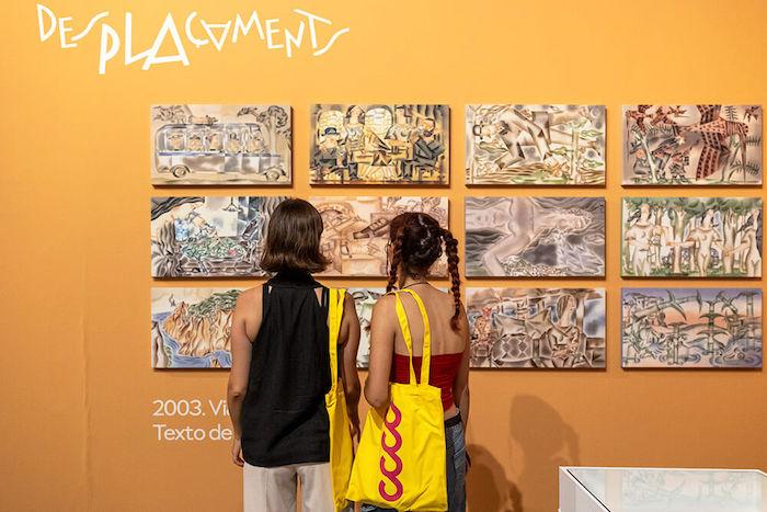 deux personnes de dos en train de regarder l'exposition Trànsit il·lustrat de l'illustrateur Miguel Calatayud au Centre del Carme de Valencia