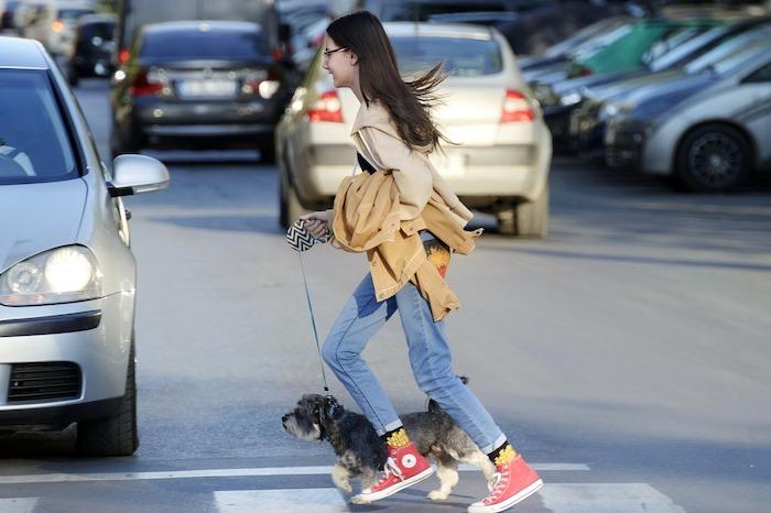 une fille promene son chien dans la rue