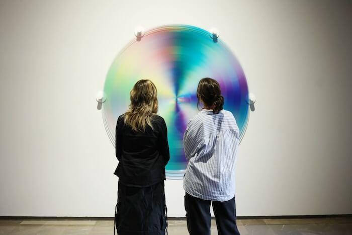 Deux femmes de dos en train de regarder un tableau de l'artiste Felipe Pantone au Centre del Carme dans l'exposition ‘Prospectiva’