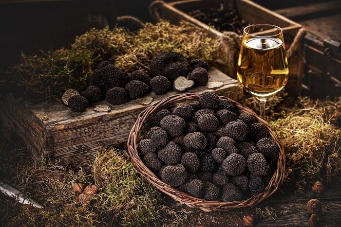 des truffes noires dans un panier à côté dún verre de vin blanc