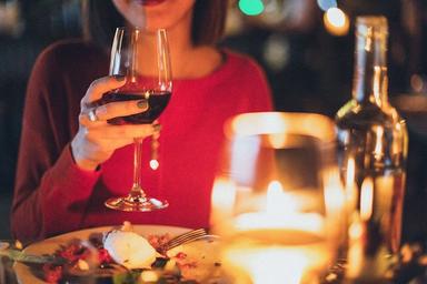 une femme avec un verre de vin rouge dans sa main lors d'un diner de saint-valentin à valencia