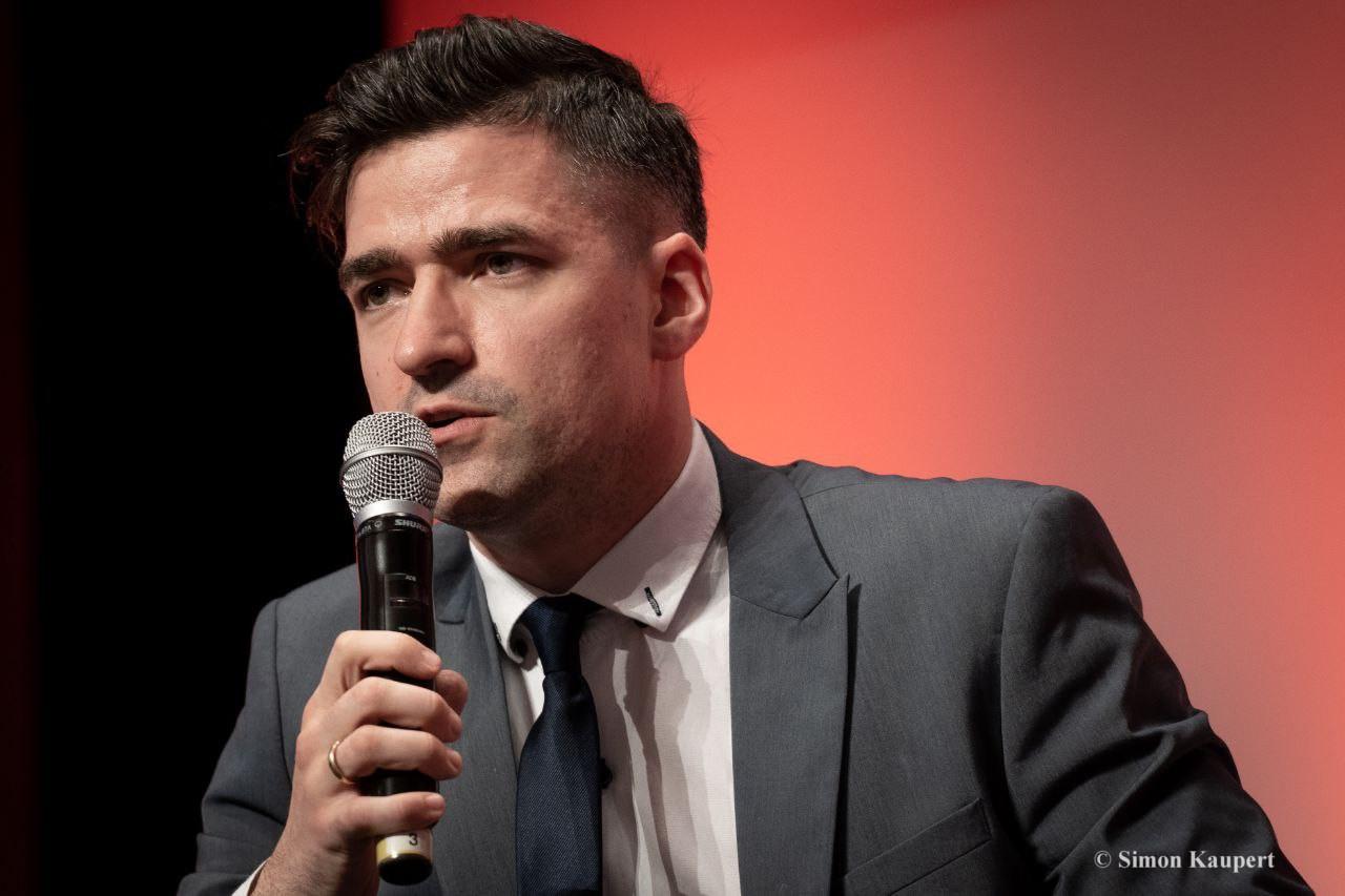 Martin Sellner en discours, tenant un micro