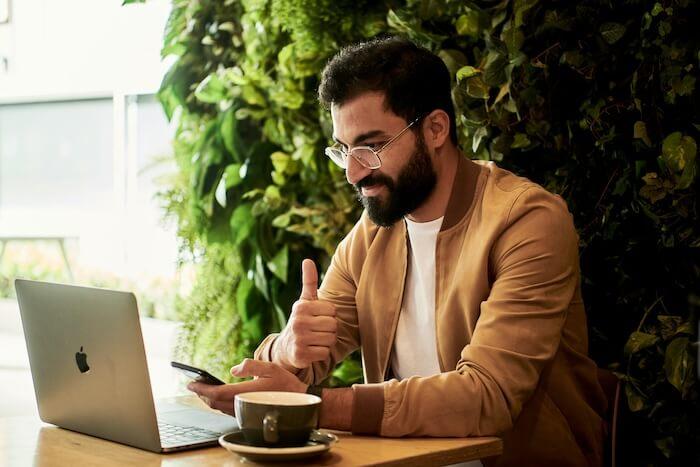 Homme avec barbe et lunettes en train de travailler dans un café à valencia