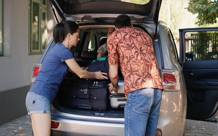 parents-mettent-leurs-bagages-dans-coffre-voiture-pendant-que-leur-fille-non-patiente-presse-famille-positive-se-prepare-pour-excursion-ete-tout-chargeant-vehicule-chariots-voyage-citybreak_482257-48249