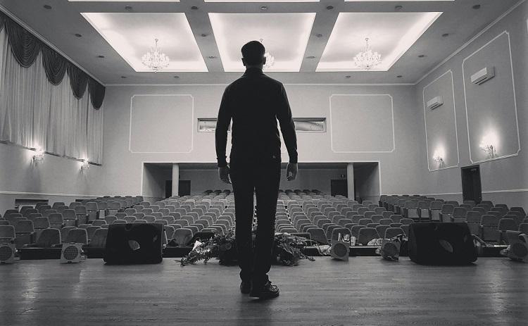 un homme debout sur la scène d'un théâtre