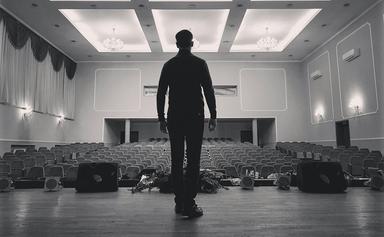 un homme debout sur la scène d'un théâtre